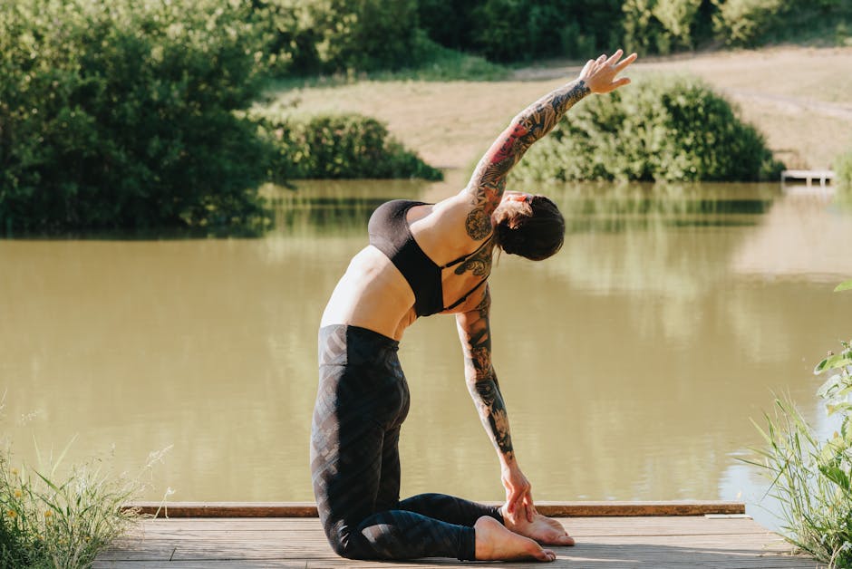 Woman in white clothes performing a yoga pose on a wooden pier by a serene lake